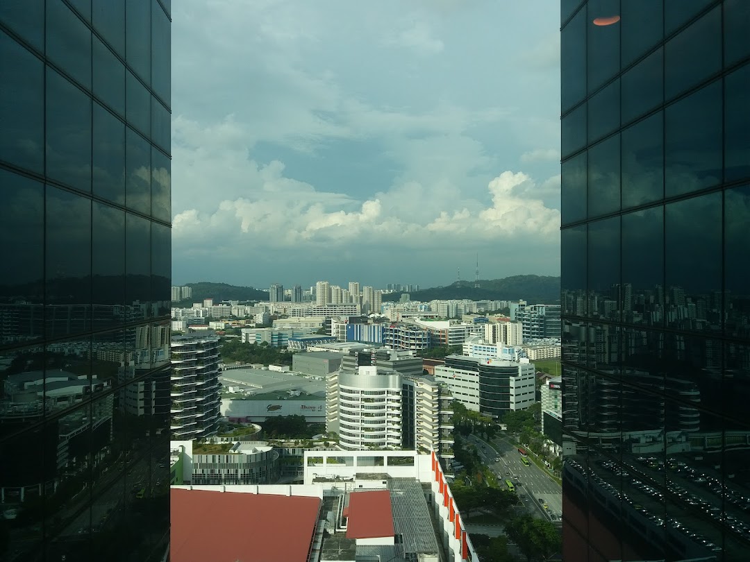 City skyline view from a building, framed by reflective glass windows.