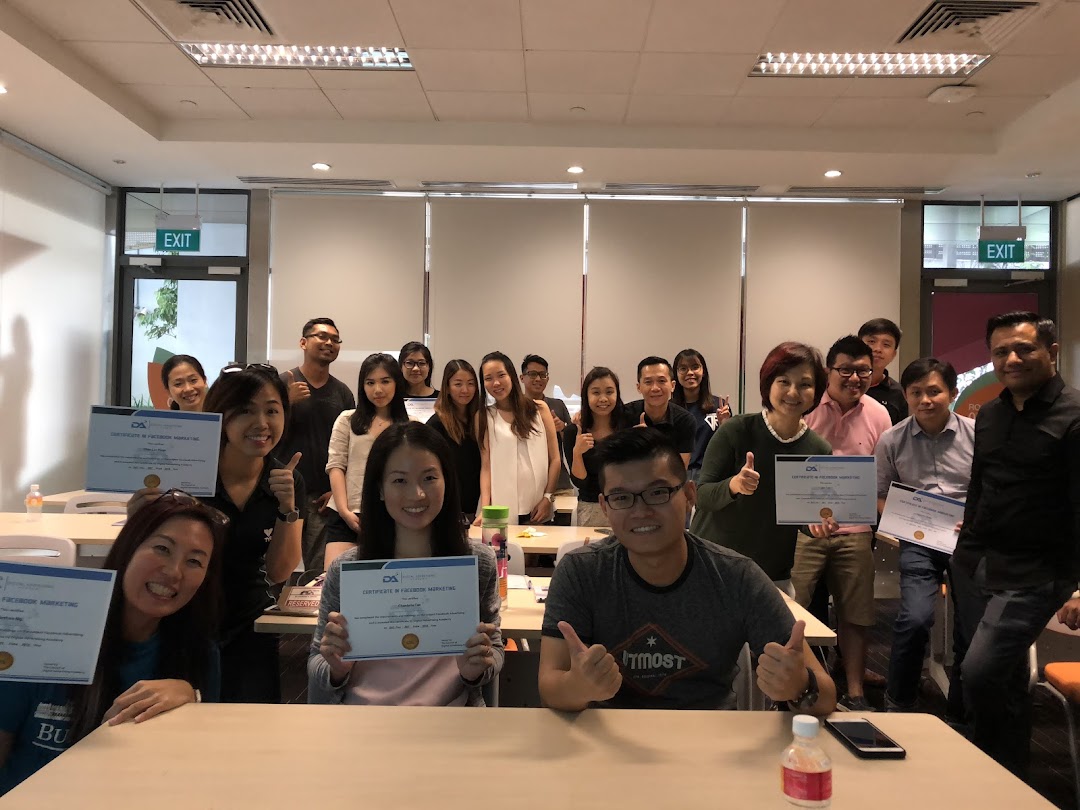 A group of people smiling and holding certificates in a classroom setting.