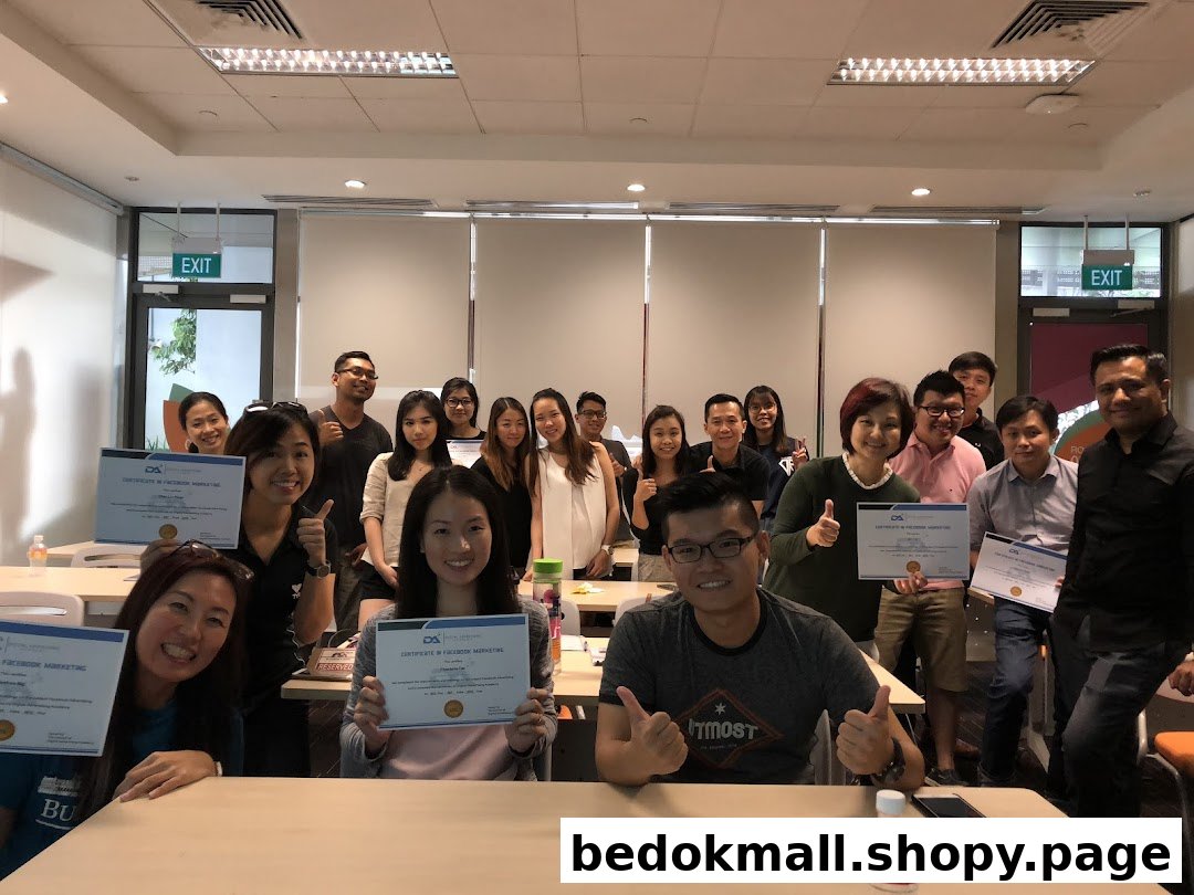 A group of people smiling and holding certificates in a classroom setting.