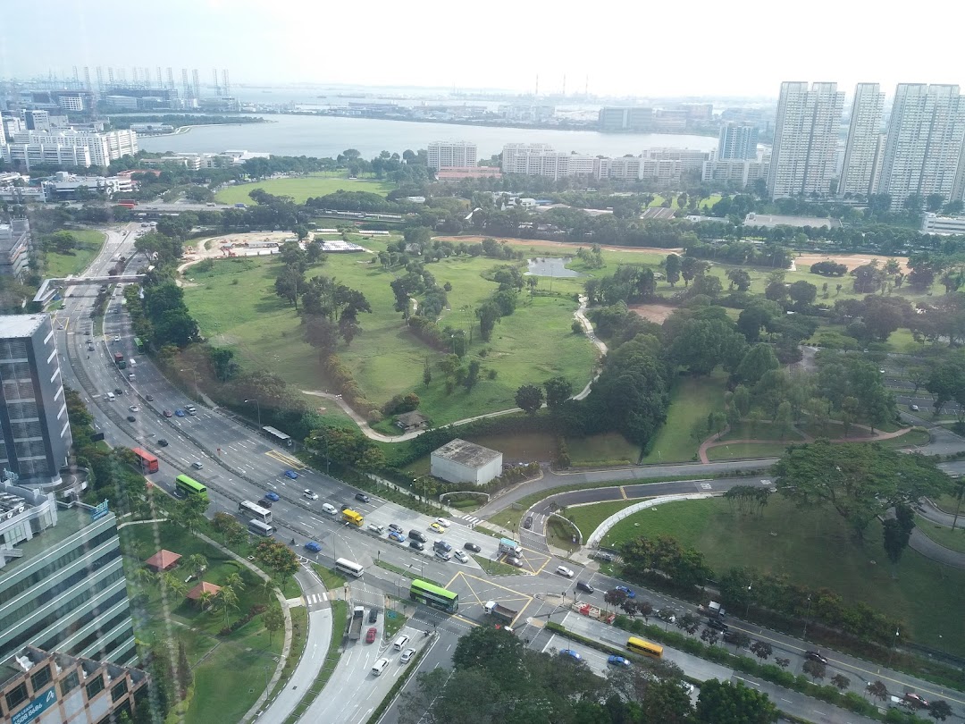 Aerial view of a city with roads, park, buildings, and a body of water.