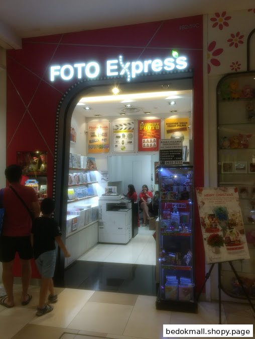 Exterior view of Foto Express shop with customers at entrance.