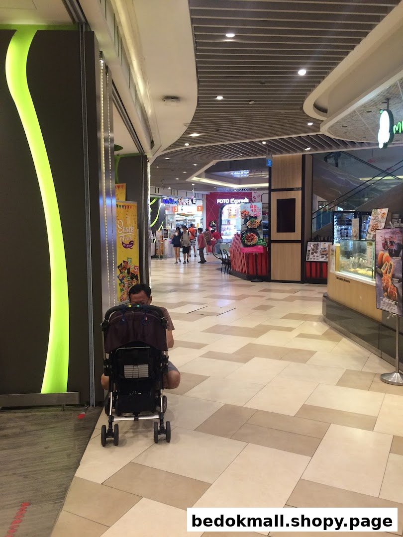 Mall corridor with shops, including Foto Express, and a person with a stroller.
