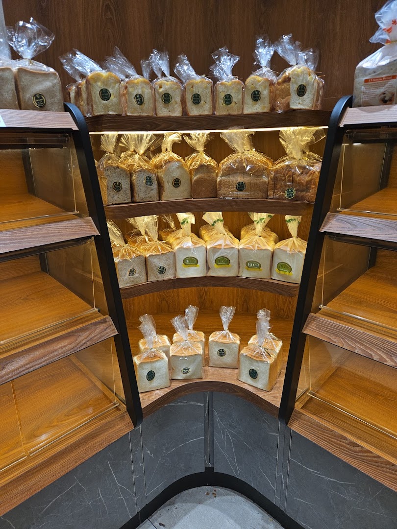 Shelves filled with packaged bread loaves inside a bakery.