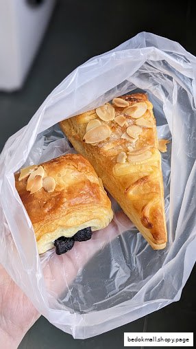 Two pastries, one chocolate and one almond, in a clear plastic bag.