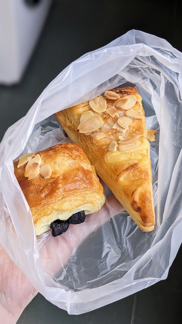 Two pastries in a plastic bag held by a hand.