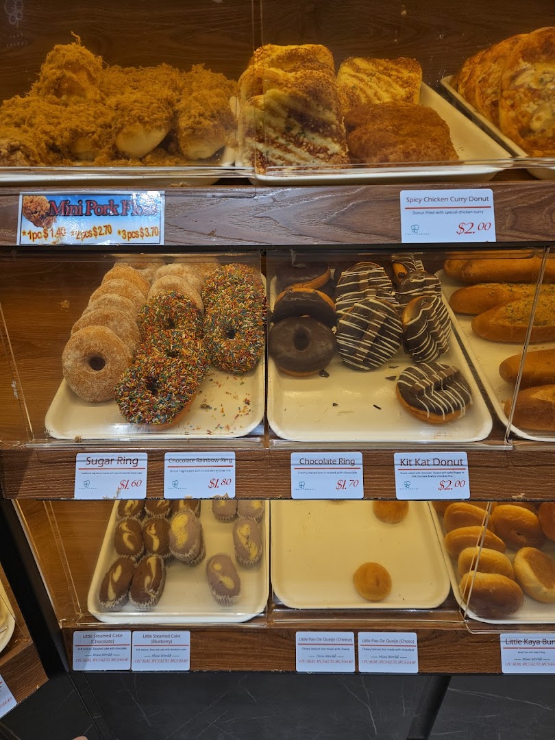 Close-up of a bakery display case showing various pastries and donuts.