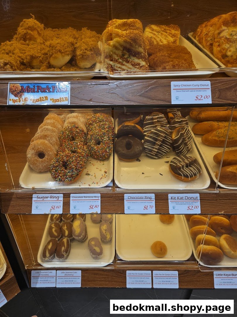Close-up of a bakery display case showing various pastries and donuts.