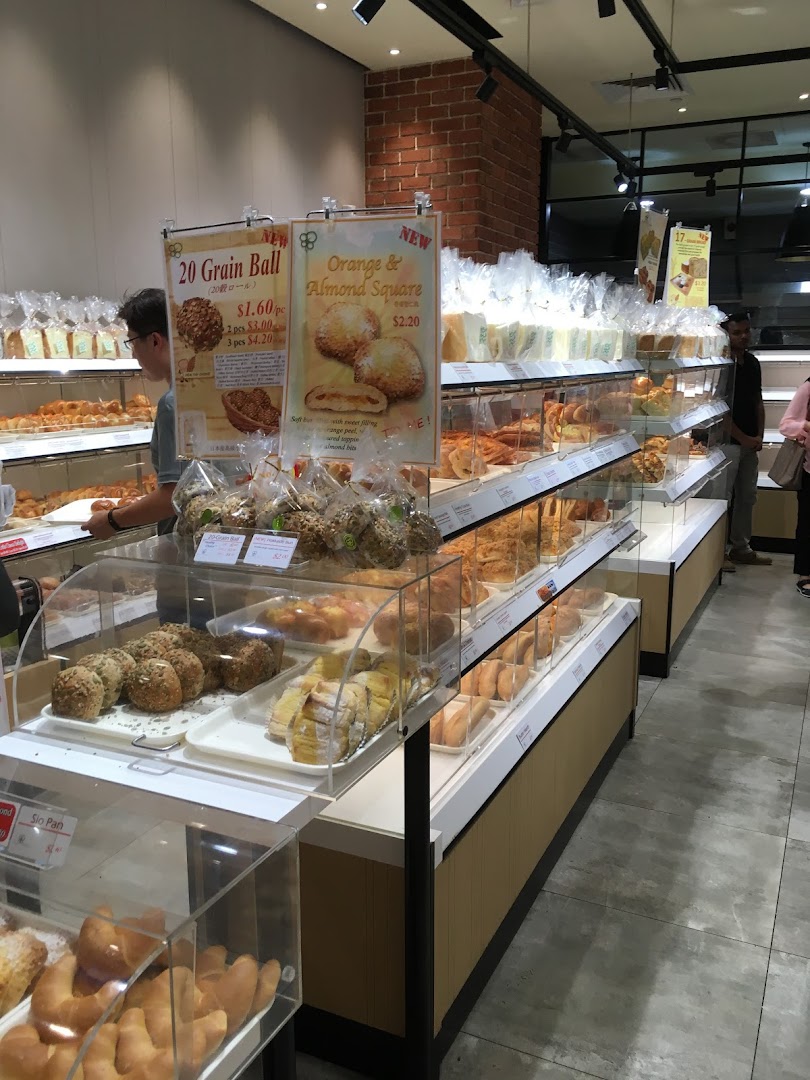 Interior view of a bakery with display cases full of bread and pastries.