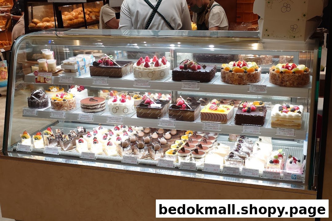 A display case filled with various cakes and pastries inside a bakery.