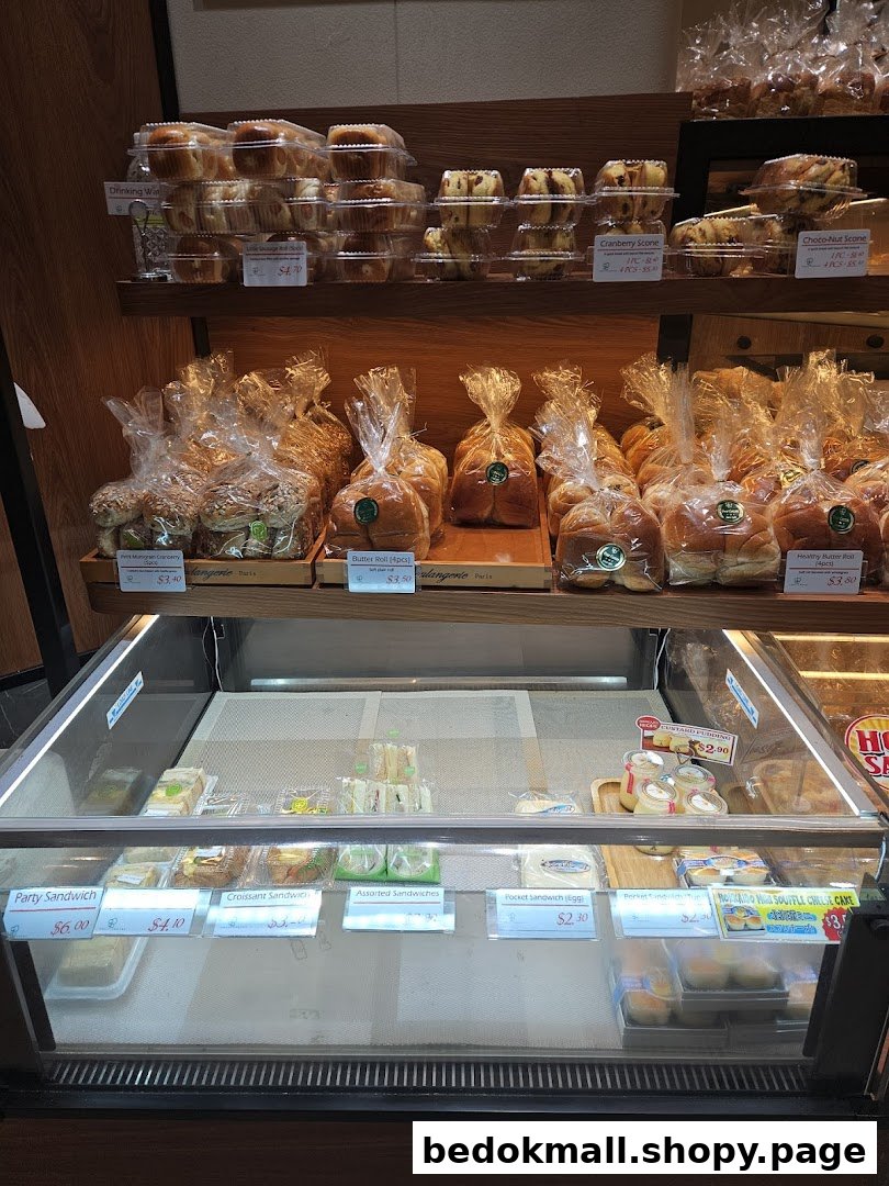 Interior view of a bakery display with various packaged bread, pastries, and sandwiches.