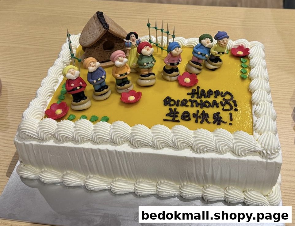 A birthday cake decorated with Snow White and Seven Dwarfs figures.