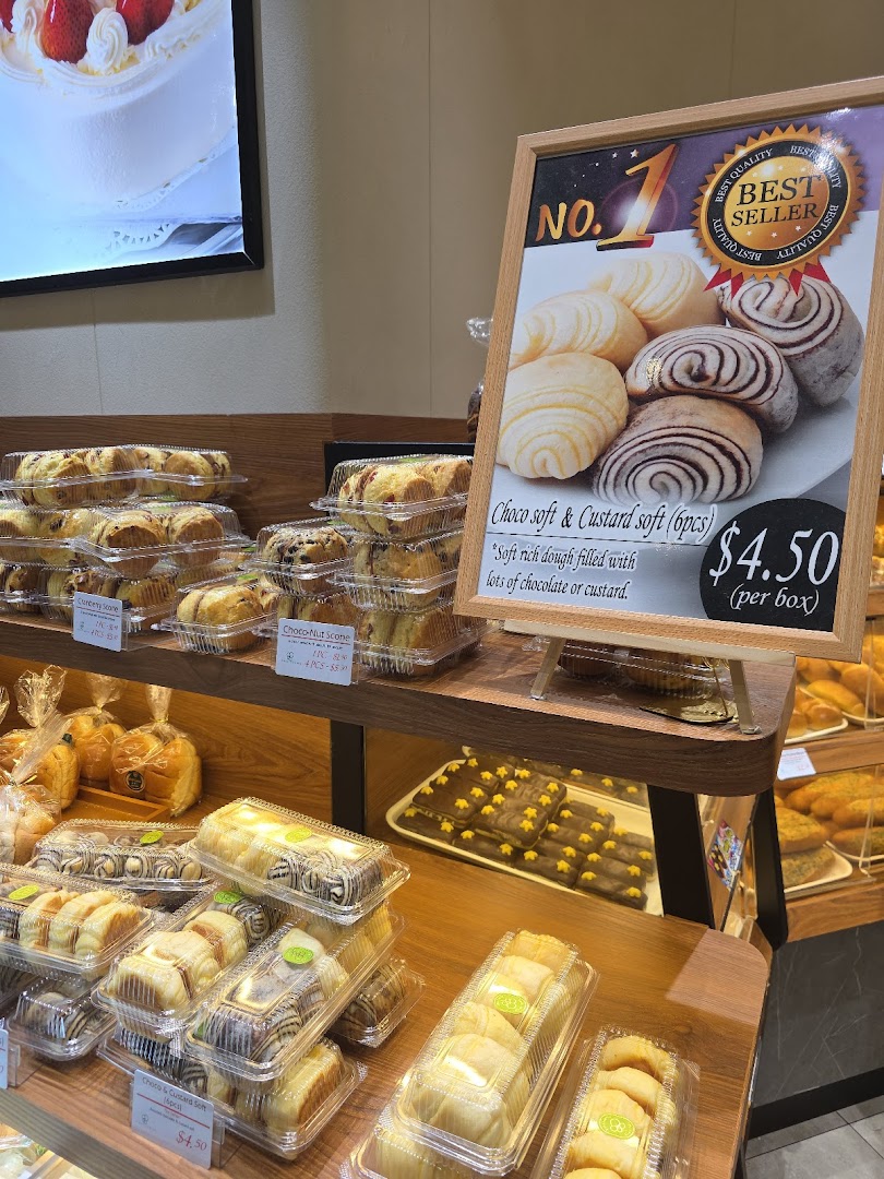 Bakery display with many packaged pastries on wooden shelves and a "Best Seller" sign.