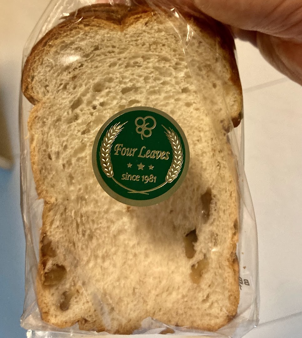A slice of bread in plastic packaging with a 'Four Leaves' label.