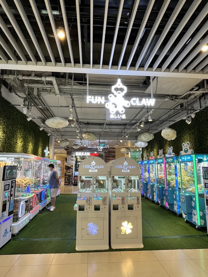 Interior of Fun Claw arcade with numerous claw machines and a person.