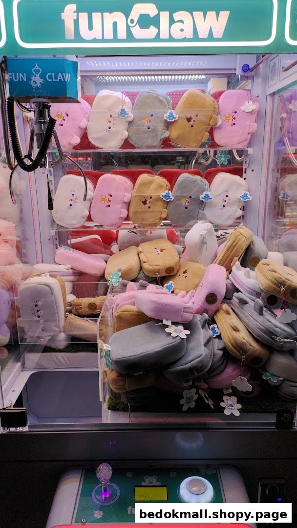 Claw machine filled with colorful plush pouches and control panel.