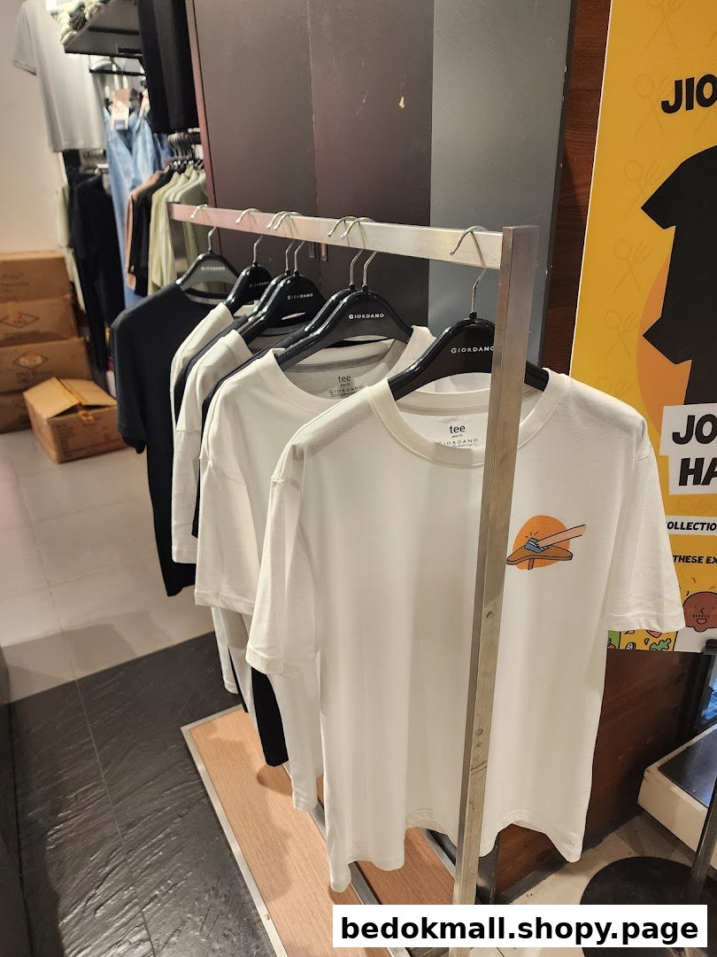 Clothing rack with white t-shirts inside a retail store.
