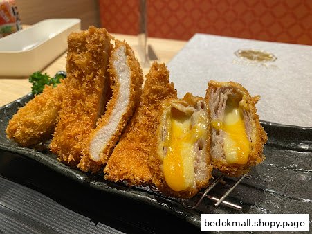Plate of fried cutlets, some filled with melted cheese.