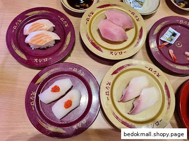 Various sushi and sashimi plates on a wooden table.