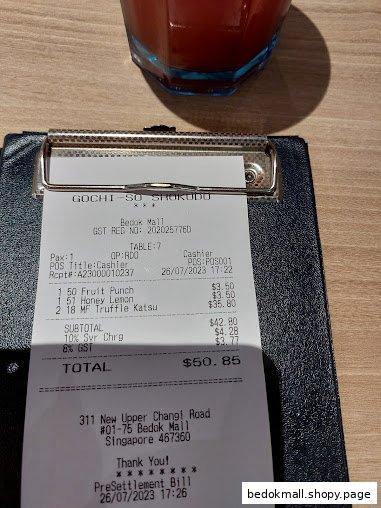 A close-up of a restaurant bill on a clipboard with a drink.