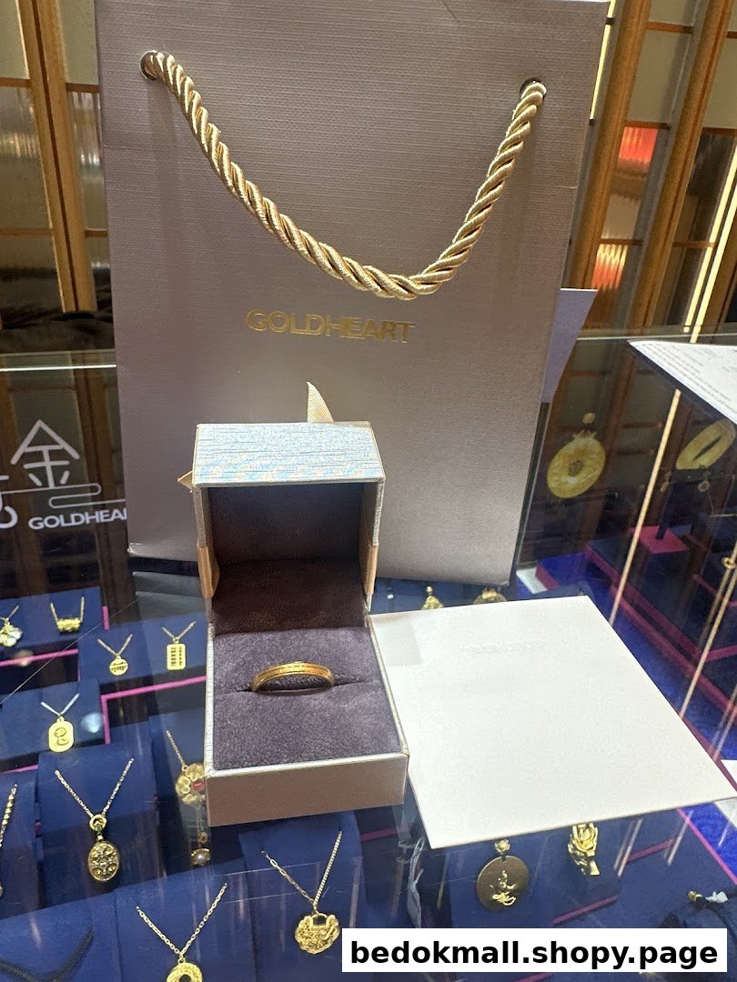 Gold ring in an open box with a Goldheart bag and jewelry display.
