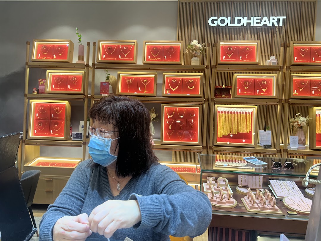Interior of a jewelry shop with displays and a person at the counter.