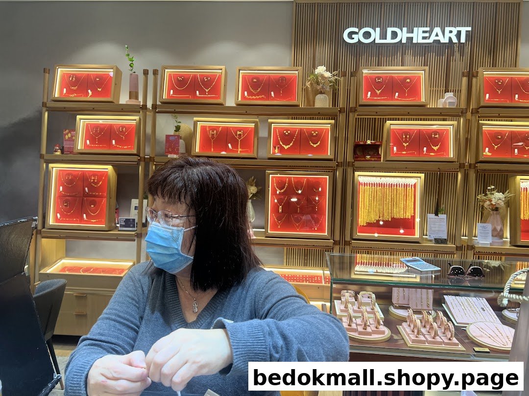 Interior of a jewelry shop with displays and a person at the counter.