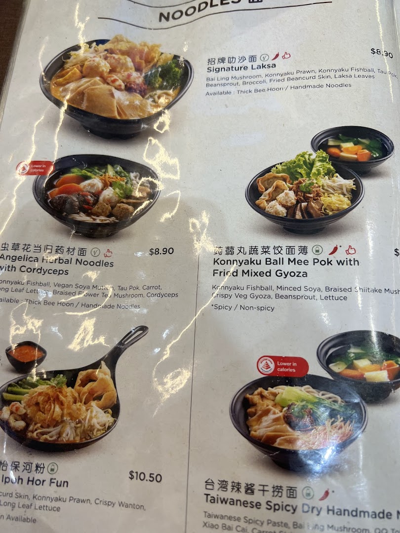 A close-up of a food menu displaying various noodle dishes with prices.