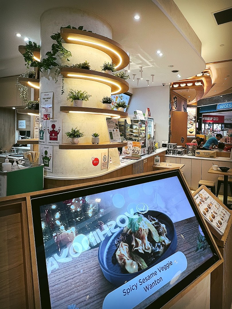 Interior view of a shop with a large digital food display and decorative pillar.