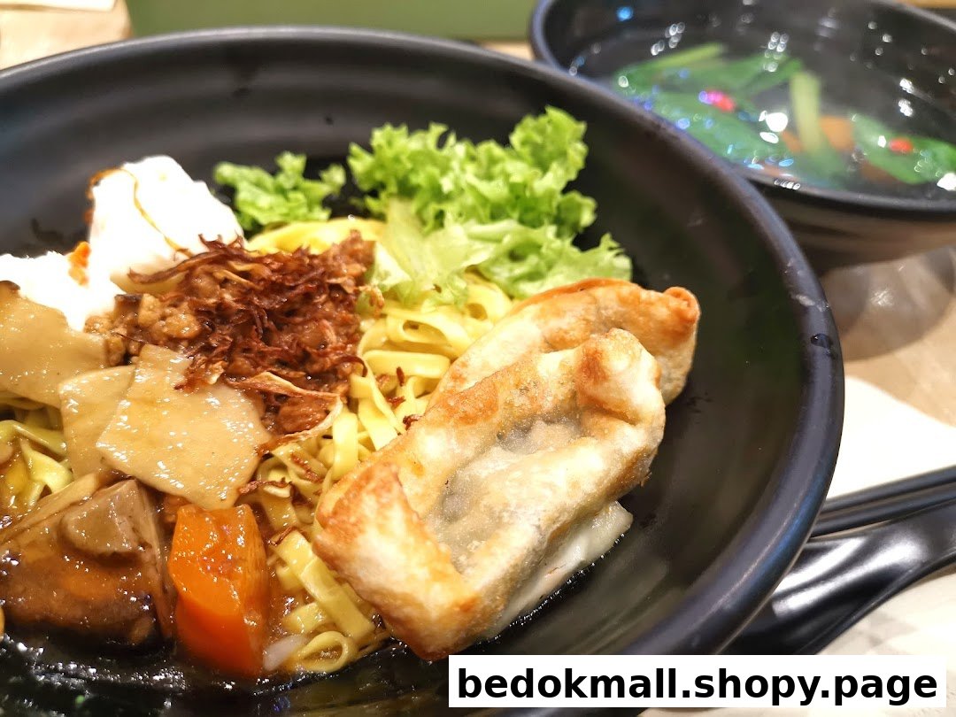 Close-up of a bowl of noodles with various toppings and a side of soup.