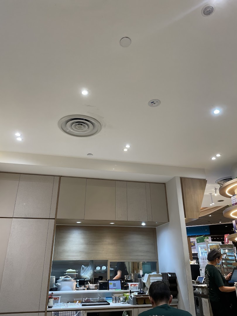 Interior view of a shop counter with staff and kitchen equipment.