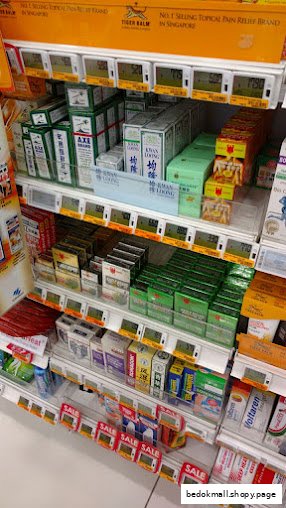 A retail shelf displaying various packaged health and beauty products with price tags.