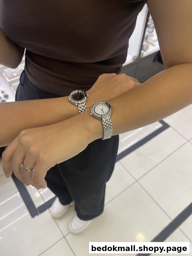 Two people's arms wearing watches in a retail shop setting.