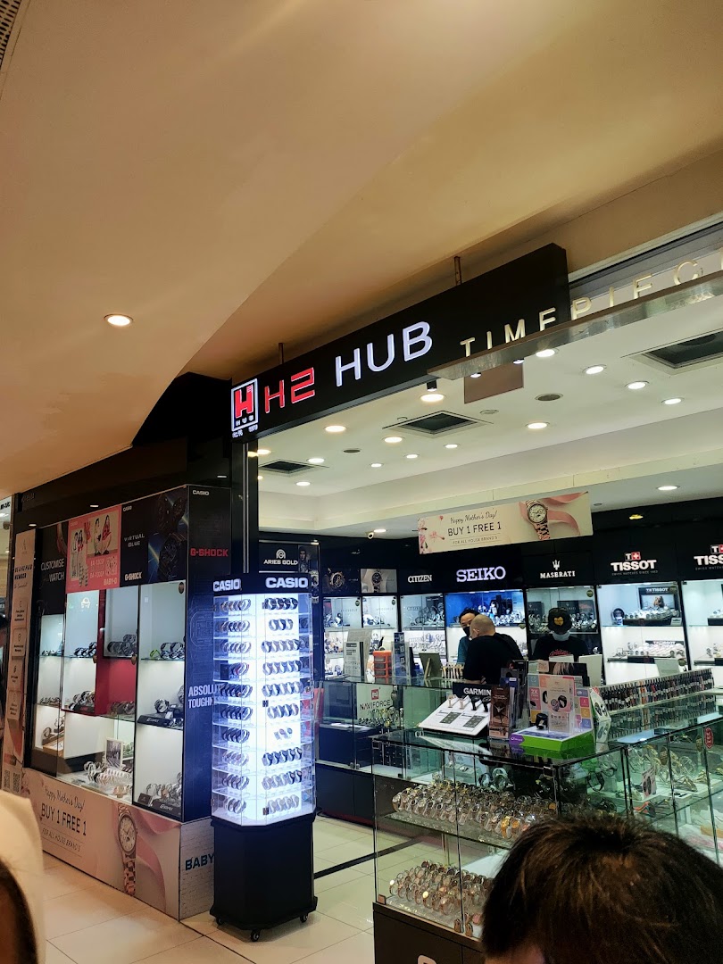 Interior view of a watch shop with display cases and staff.