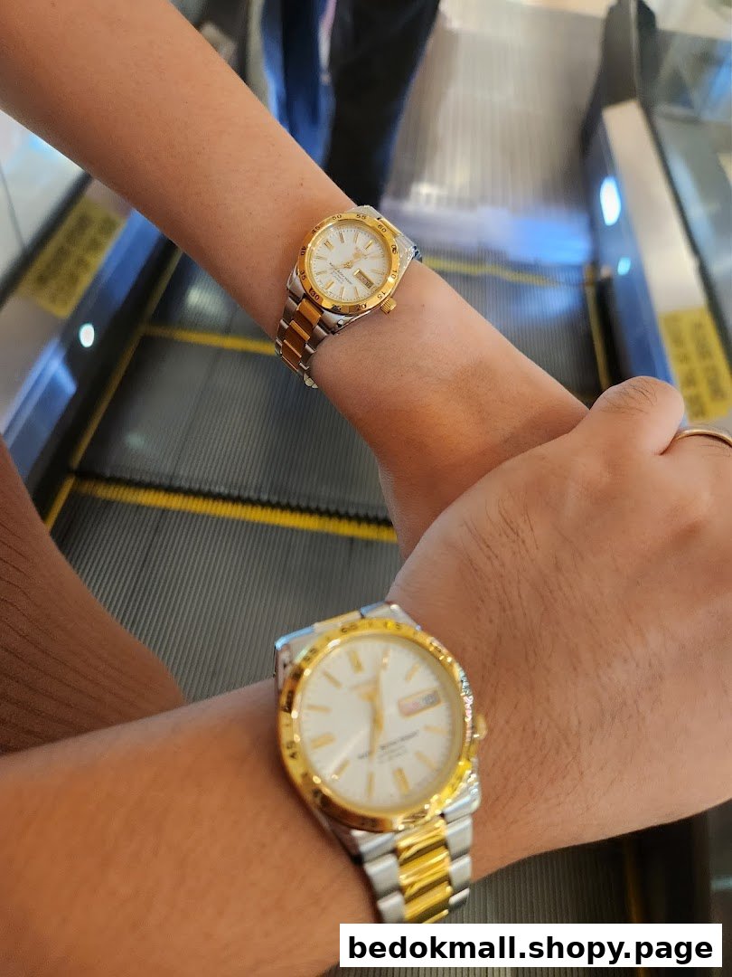 Two people wearing watches on an escalator.