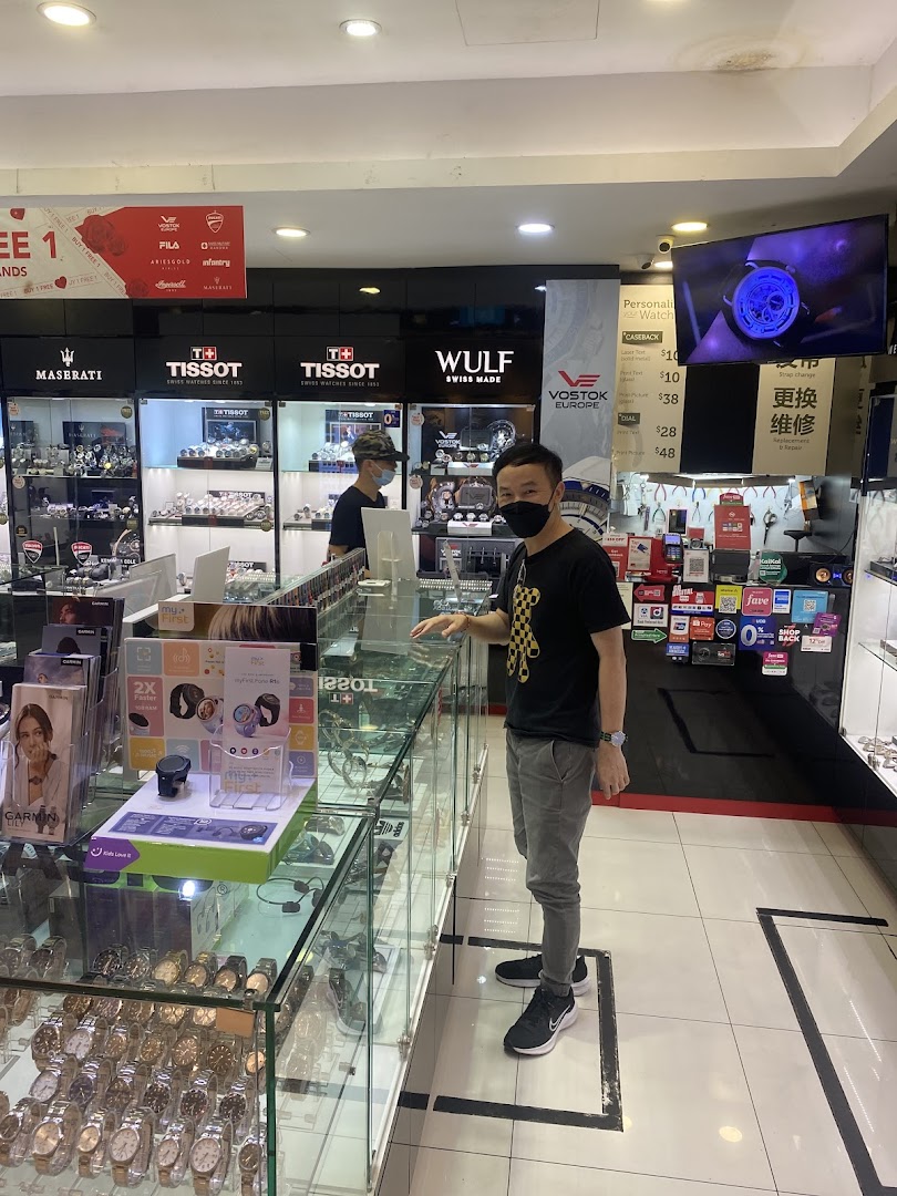 Watch shop interior with display cases, products, and two masked individuals.