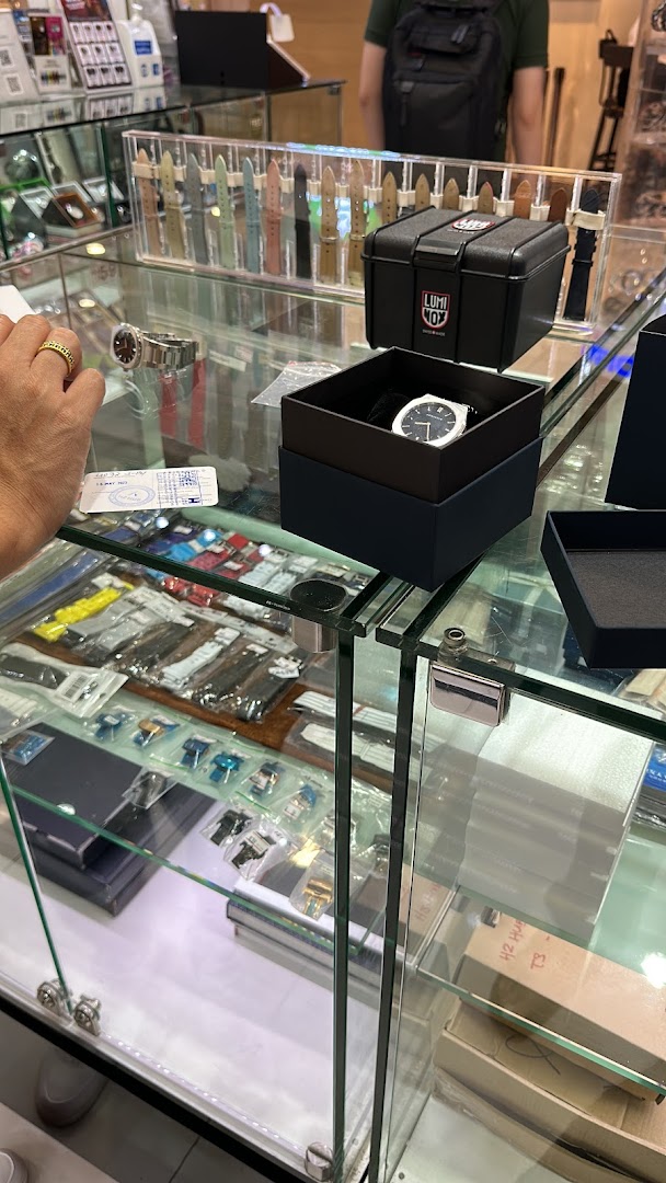 Close-up of a watch shop display case with watches and accessories.