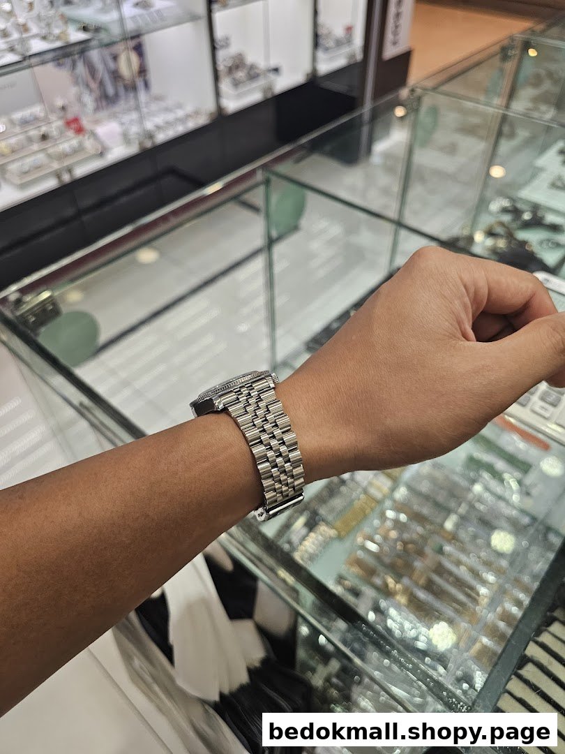 Person's arm wearing a watch inside a shop with display cases.