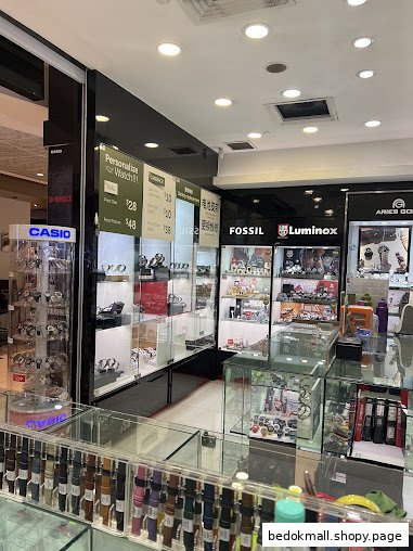 Interior view of a watch shop with various brands displayed in glass cases.