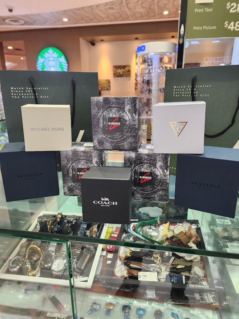 Display of branded watch boxes and shopping bags on a retail counter.