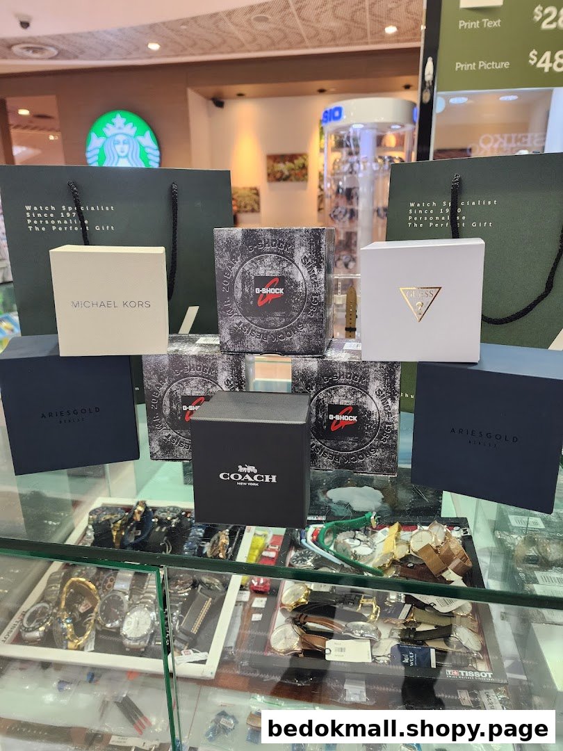 Display of branded watch boxes and shopping bags on a retail counter.