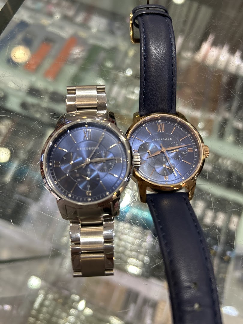 Two blue-faced watches, one metal and one leather band, on display.