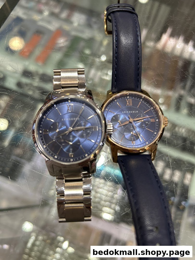 Two blue-faced watches, one metal and one leather band, on display.