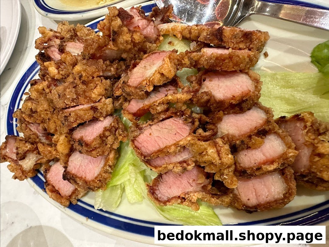 A plate of crispy fried pork slices with lettuce on a white and blue rimmed plate.