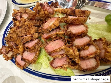 A plate of crispy fried pork slices served on lettuce.