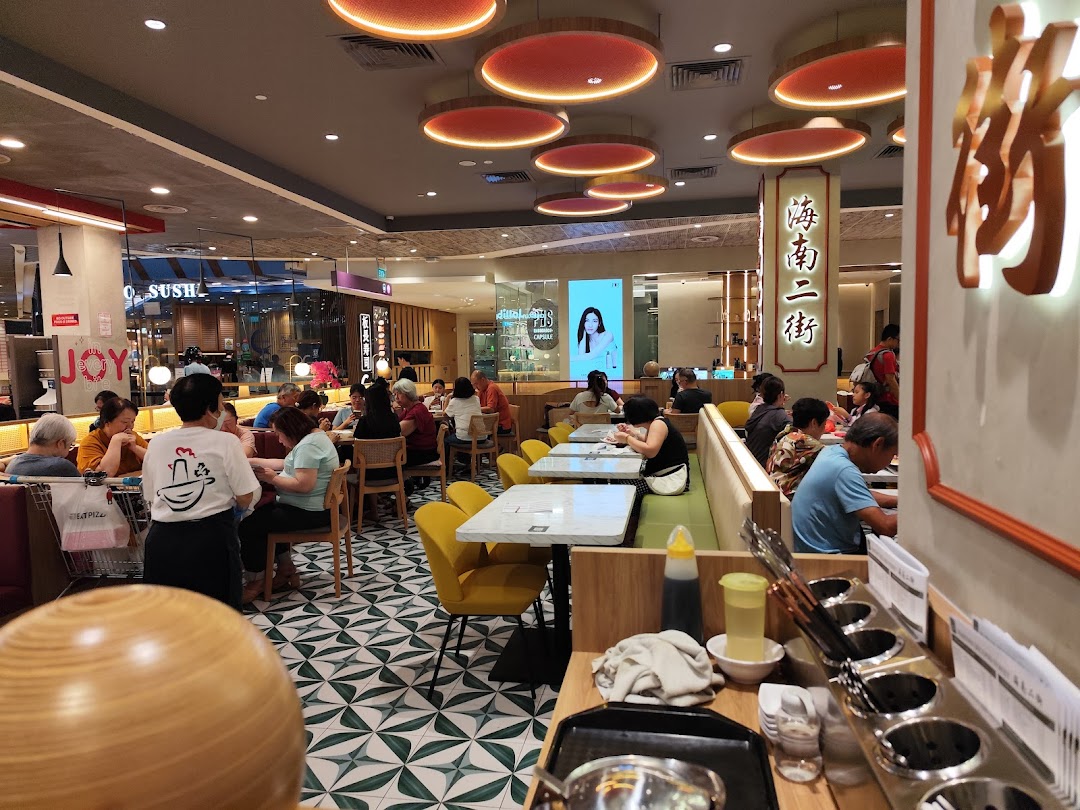 Customers dining inside a busy restaurant with staff present.