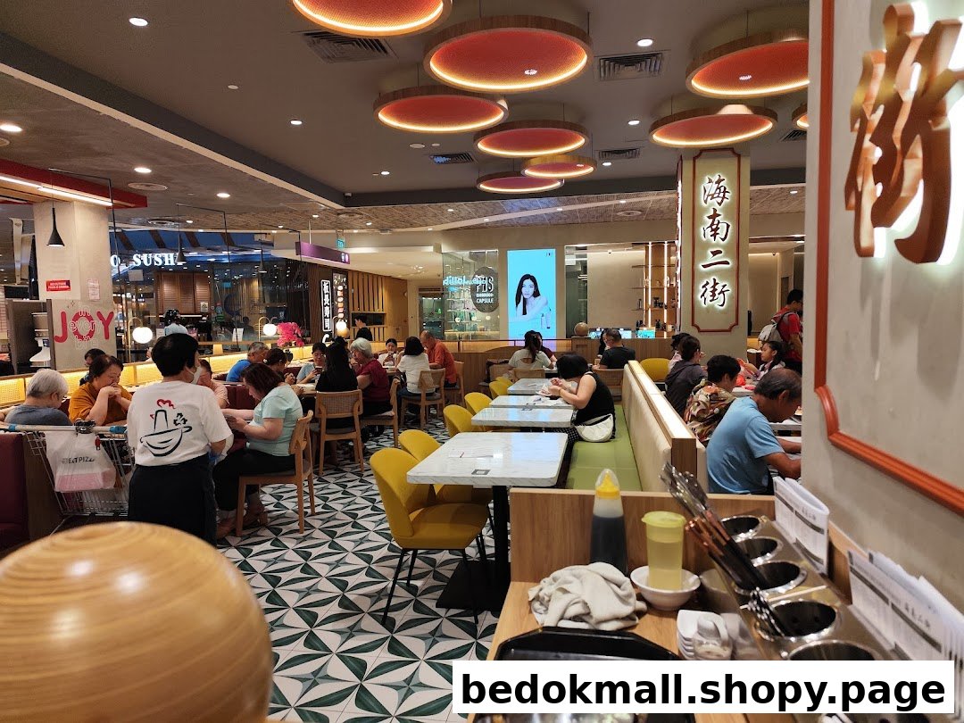 Customers dining inside a busy restaurant with staff present.