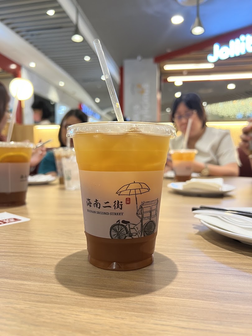 A drink cup from Hainan Second Street on a table inside a food court.