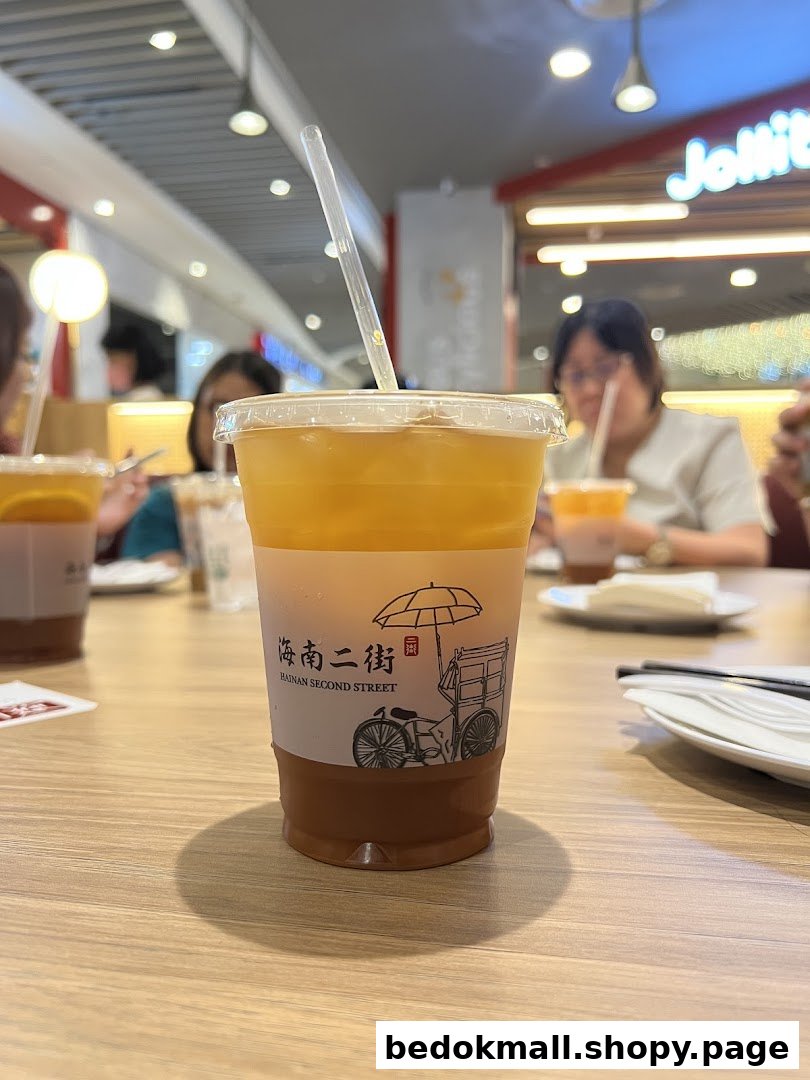 A drink cup from Hainan Second Street on a table inside a food court.