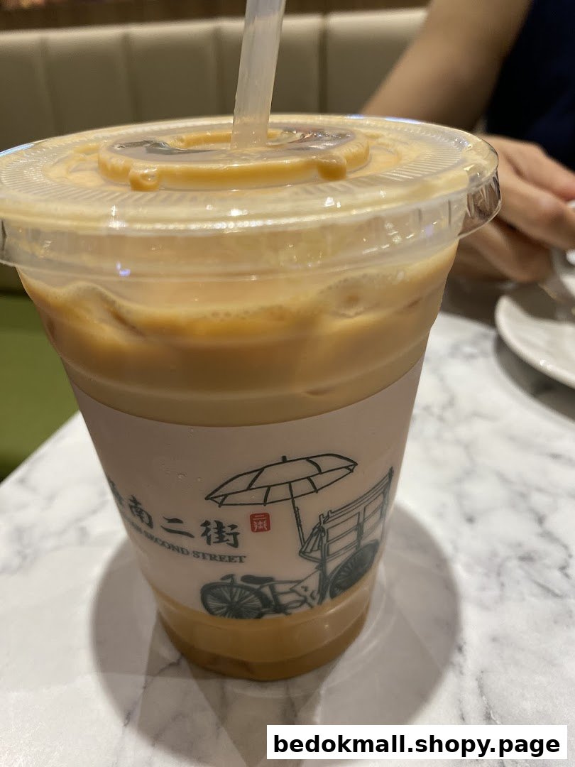 A plastic cup of iced beverage with a straw on a marble table.