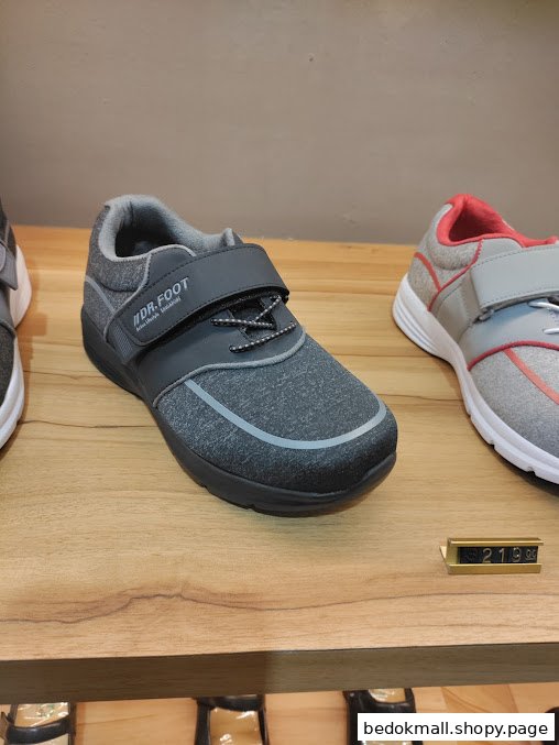 Two pairs of shoes displayed on a wooden shelf in a retail store.